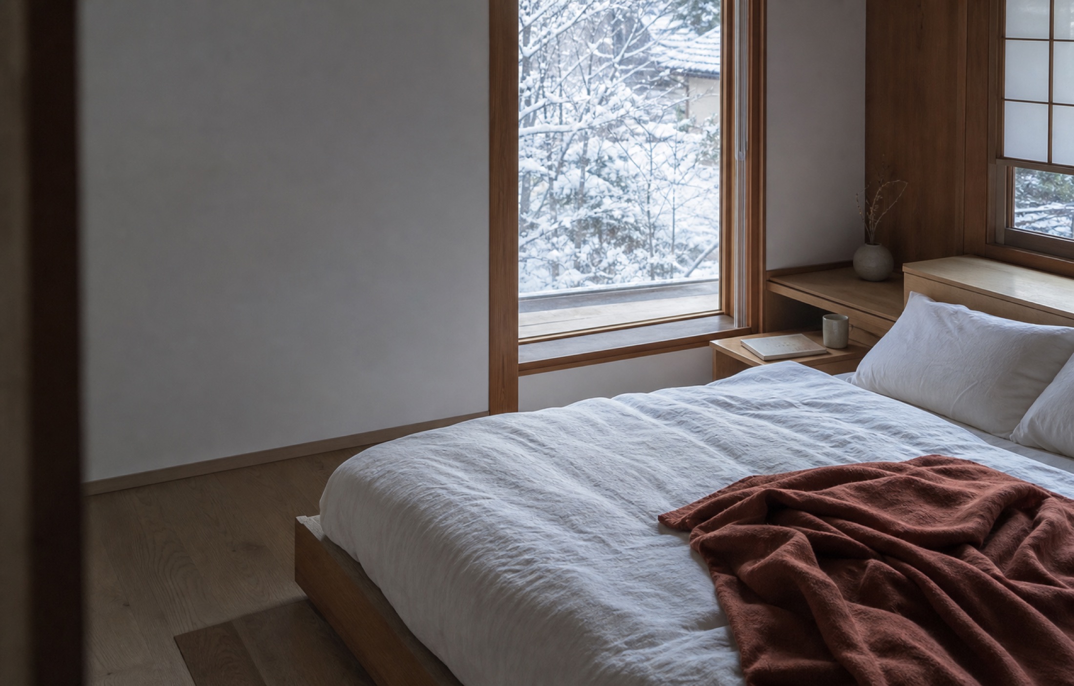 雪の朝、白い寝具が整えられた静かな寝室